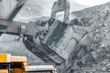 Wall Mural - Powerful and large excavator bucket. Loading of minerals into the body of a mining truck.