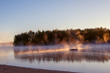 Wall Mural - A gentle morning on the lake with fog over the water in the sun. USA. Maine