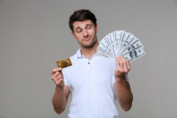 Poster - Thinking man holding money and debit card.