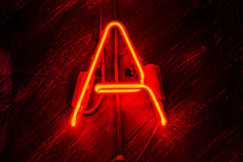 Glowing Neon Red Letter A On Wooden Background