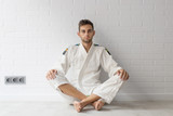 young sportsman sitting in the gym, martial arts or yoga