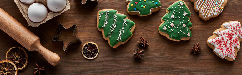 Canvas Print - top view of Christmas tree cookies, dough molds, eggs and rolling pin on wooden table, panoramic shot