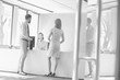 © MDBPIXS - Black and white photo of business people waiting while receptionist calling manager in office lobby