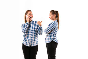 Young handsome woman arguing with herself on white studio background. Concept of human emotions, expression, mental issues, internal conflict, split personality. Half-length portrait. Negative space.