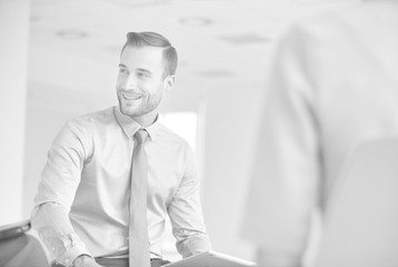 Wall Mural - Smiling young businessman sitting with colleague during meeting at new office