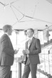 © MDBPIXS - Black and white photo of Businessmen discussing while standing at new office