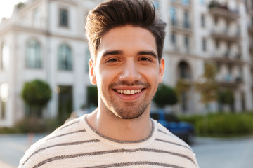 Sticker - Image of pleased handsome man smiling and looking at camera