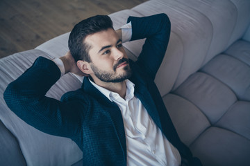 Sticker - High angle view photo of handsome business guy sitting minded hands behind head on comfort sofa in apartment office building indoors wear formalwear costume