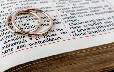 Two wedding rings on a bible page