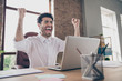 We got new partnership yes. Portrait of crazy delighted middle eastern arabian businessman sit desktop got message on computer about start-up success scream yeah raise fists in loft workplace