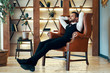 © GVS - Confident young man relax in armchair in luxury interior