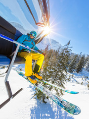 Poster - Skier sitting at ski lift in high mountains during sunny day