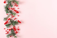 Christmas Modern Composition. Fir Tree Branches, Red Berries, Xmas Decorations On Pastel Pink Background. Christmas, New Year, Winter Concept. Flat Lay, Top View, Copy Space