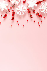 Wall Mural - christmas modern composition. xmas decorations, red berries, snowflakes on pastel pink background. c