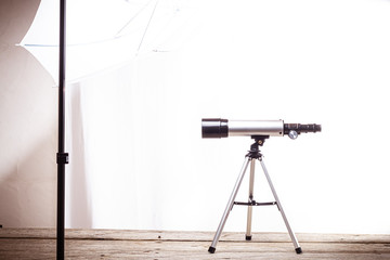 Wall Mural - telescope on a white background laid on wooden board