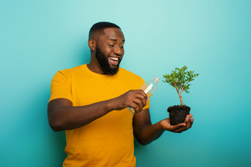 Wall Mural - Happy boy watering a small tree ready to be planted. Concept of forestation