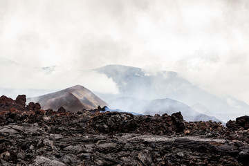 Wall Mural - Foggy volcanic landscape near Volcano Tolbachik in the overcast weather. Kamchatka Peninsula, Russia