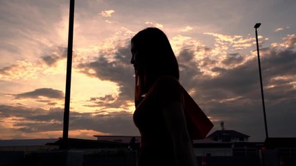 Sticker - slow-motion of woman walking with shopping bags at sunset