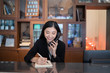 © Have a nice day  - Welcome to the hotel,Happy young Asian woman hotel receptionist worker smiling standing,she taking  telephone call at a Modern luxury reception counter waiting for guests getting key card in hotel