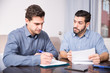 © JackF - Two serious males with documents at table