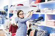© Natalia - Teen girl choosing clothing at the store. Fashion concept and trends for teenagers.