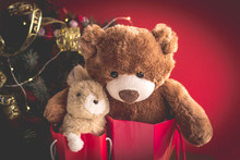 Christmas Card With Teddy And Bunny In Red Gift Bags Under The Christmas Tree.  With  Holiday Decoration And Presents