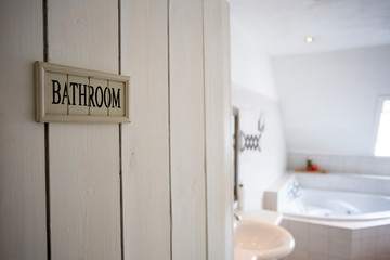 Closeup bathroom door with sign bathroom shallow depth of field, blurred background, white colors