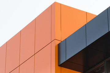 Geometric color elements of the building facade with planes, lines, corners with highlights and reflections for the abstract background and texture of red, orange, gray colors. Place for text