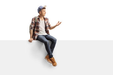 Poster - Male student sitting on a panel alone and gesturing with his hand