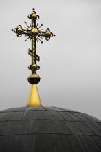 Closeup Of A Golden Decorated Cross On A Black Church Dome