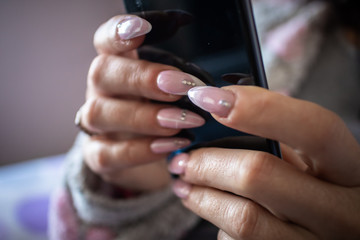 Wall Mural - Women's hands with manicured nails holds smartphone