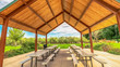 Panorama frame Eating area inside the pavilion of a park with view of trees and cloudy sky
