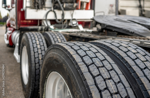 Wheels with tires on axels of big rig semi truck standing on parking lot