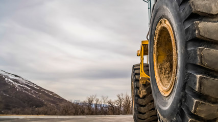 Wall Mural - Panorama Focus on the black rubber tires of a yelow bulldozer at a construction site