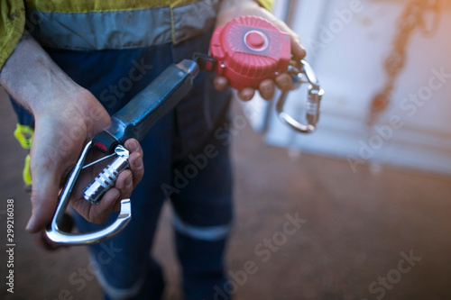 Male inspector hand testing opening locking carabiner gate which connecting with Tableau sur Toile