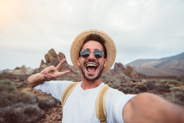 handsome hiker taking a selfie hiking a mountain using his smartphone