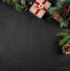 Wall Mural - Christmas fir branches, pine cones and gifts on dark background. Xmas and New Year theme. Flat lay, top view