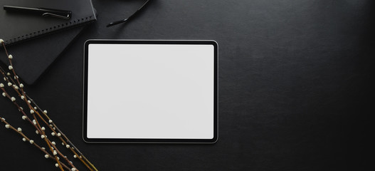 Wall Mural - Overhead shot of blank screen tablet on black desk in dark luxury workspace