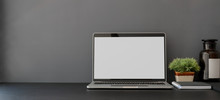 Open Blank Screen Laptop Computer In Dark Trendy Workplace With Copy Space
