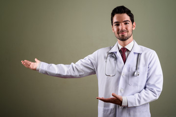 Wall Mural - Portrait of young handsome man doctor with stubble beard