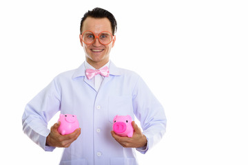 Portrait of crazy young man doctor playing with piggy bank