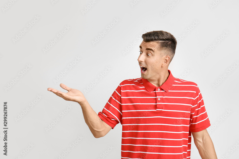 Surprised young man on light background