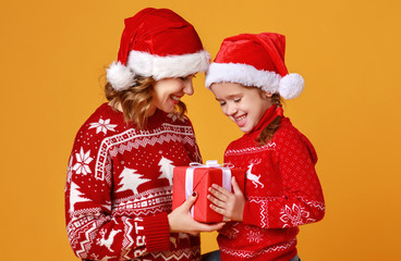 Sticker - happy family mother and child daughter  with christmas gifts on yellow background.