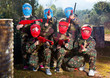 © JackF - Friendly group of children paintball players in camouflage posing with guns on paintball playing field outdoors