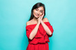 © dianagrytsku - Attractive young asian woman in red dress isolated on green background