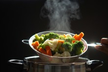 Steaming Of Hot Boiled Vegetables. Basket Of Vegetables That Just Boiled From Hot Water With Steam Selective Focus, Soft Focus. Hot Food, Diet And Healthy Concept.