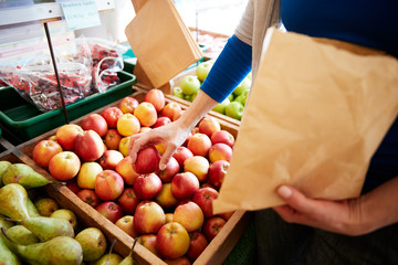 Wall Mural - Close Up Of Woman Customer With Paper Bag Buying Fresh Apples In Organic Farm Shop