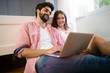 © NDABCREATIVITY - Young couple relaxing on bed with laptop. Love, technology, happiness, people and fun concept.