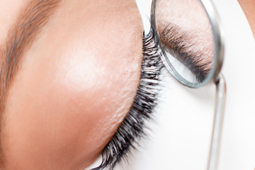 Eyelashes extensions procedure in spa beauty salon. Macro Beautiful eye with makeup