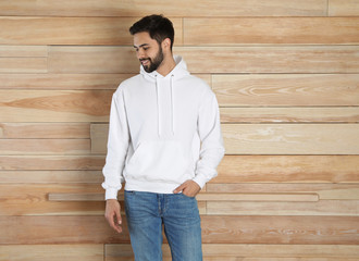 Wall Mural - Portrait of young man in sweater at wooden wall. Mock up for design